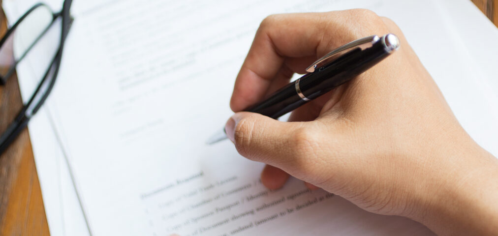 Unrecognizable man filling application form. Businessman checking papers. He signing document. Manager working with report. Financial report concept